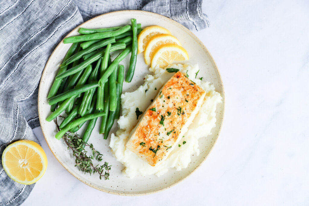 Air fryer halibut with lemon thyme butter sauce served on a plate