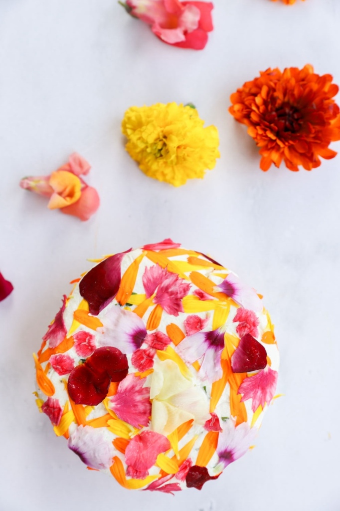 Goat cheese spread topped with edible flowers and fresh herbs