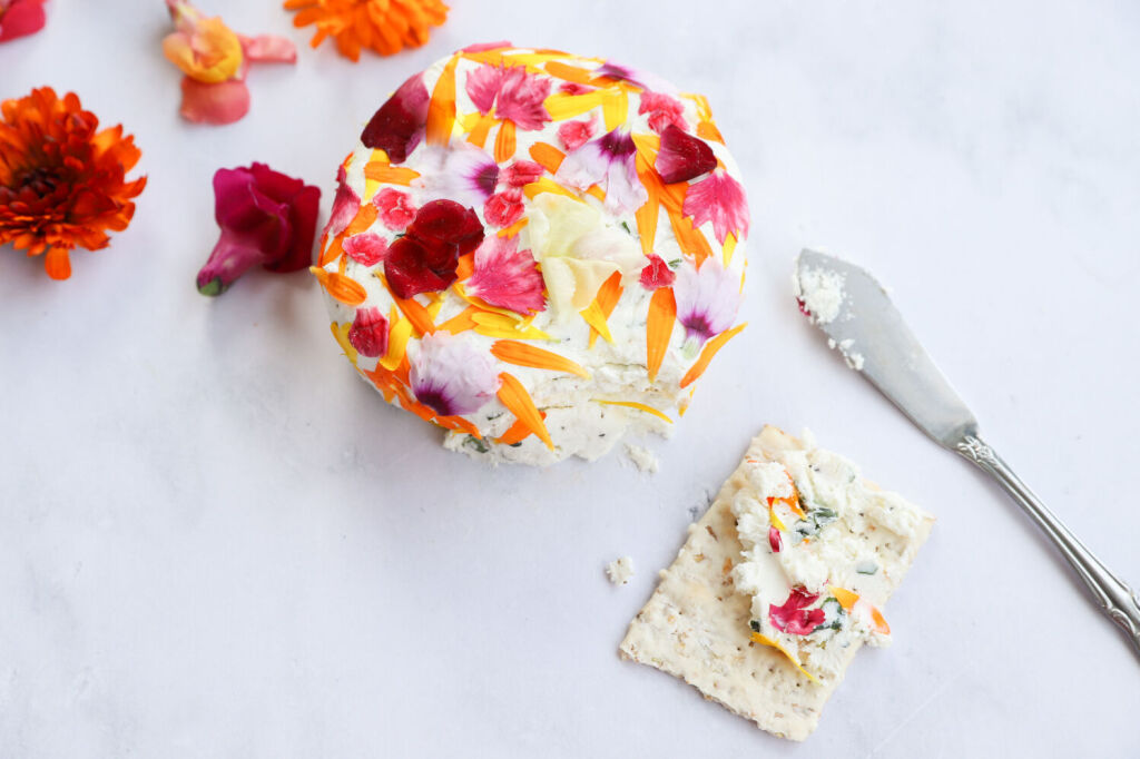 Elegant floral herb goat cheese appetizer on a platter