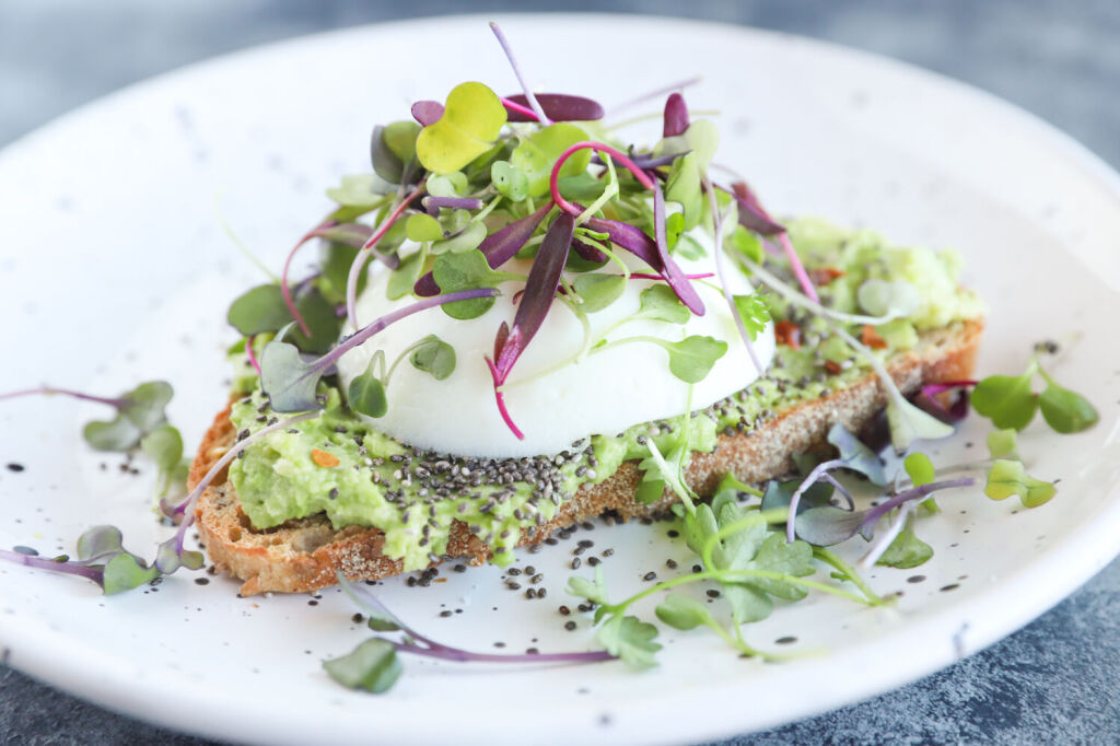 Avocado toast with microgreens, chia seeds, and a poached egg