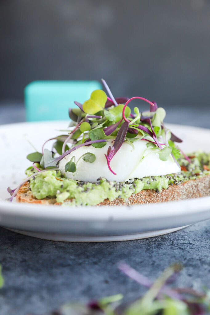 Fresh avocado toast with microgreens and a perfectly cooked egg