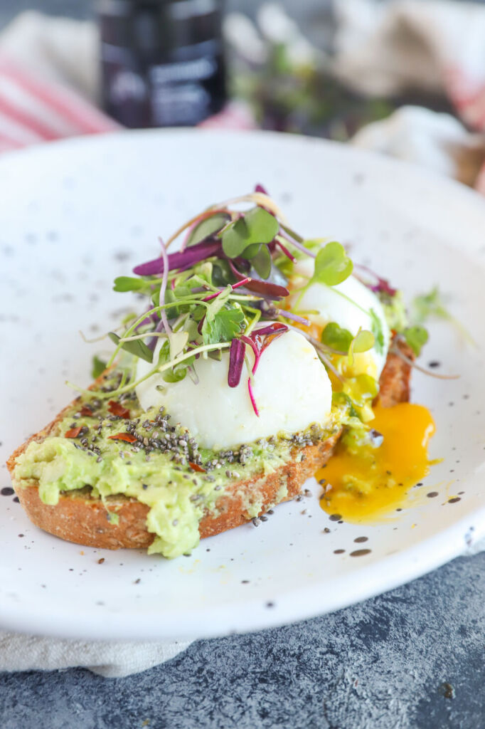 Microgreens avocado toast topped with chia seeds and a poached egg