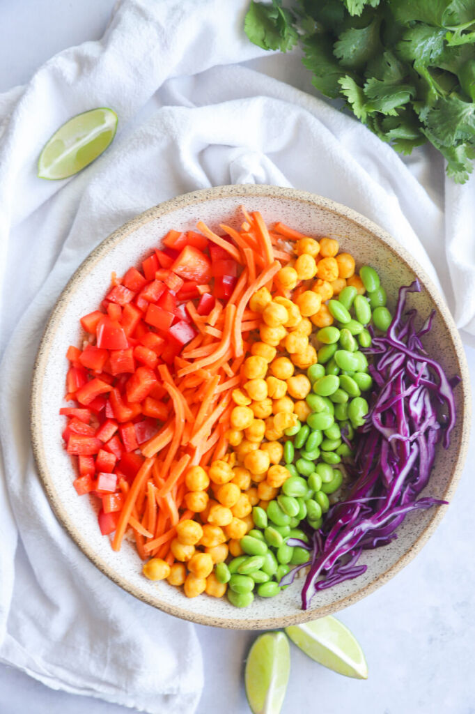 Vibrant rainbow salad bowl with purple cabbage, red bell pepper, and orange vinaigrette