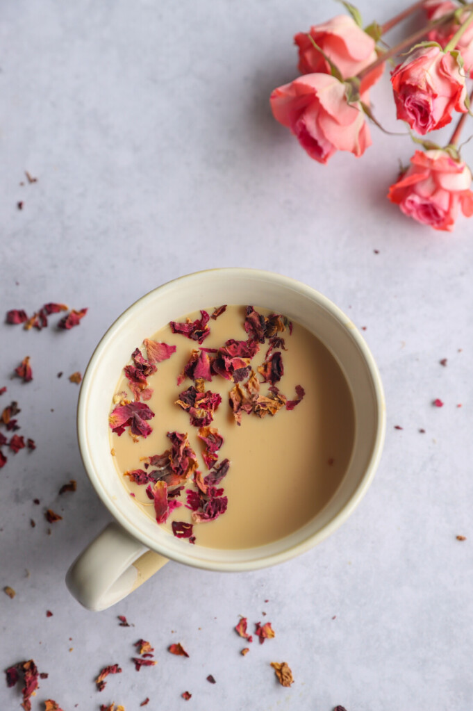 Rose Petal Milk Tea in a cup with rose petals on the side