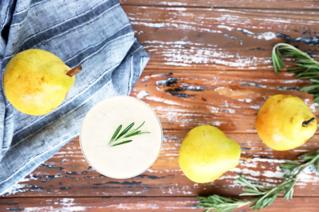 Sparkling rosemary pear mocktail in a glass with pear slices