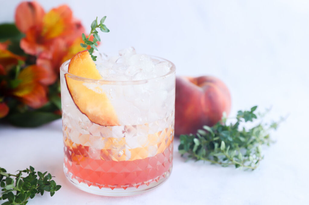 Refreshing peach mocktail with thyme in a glass