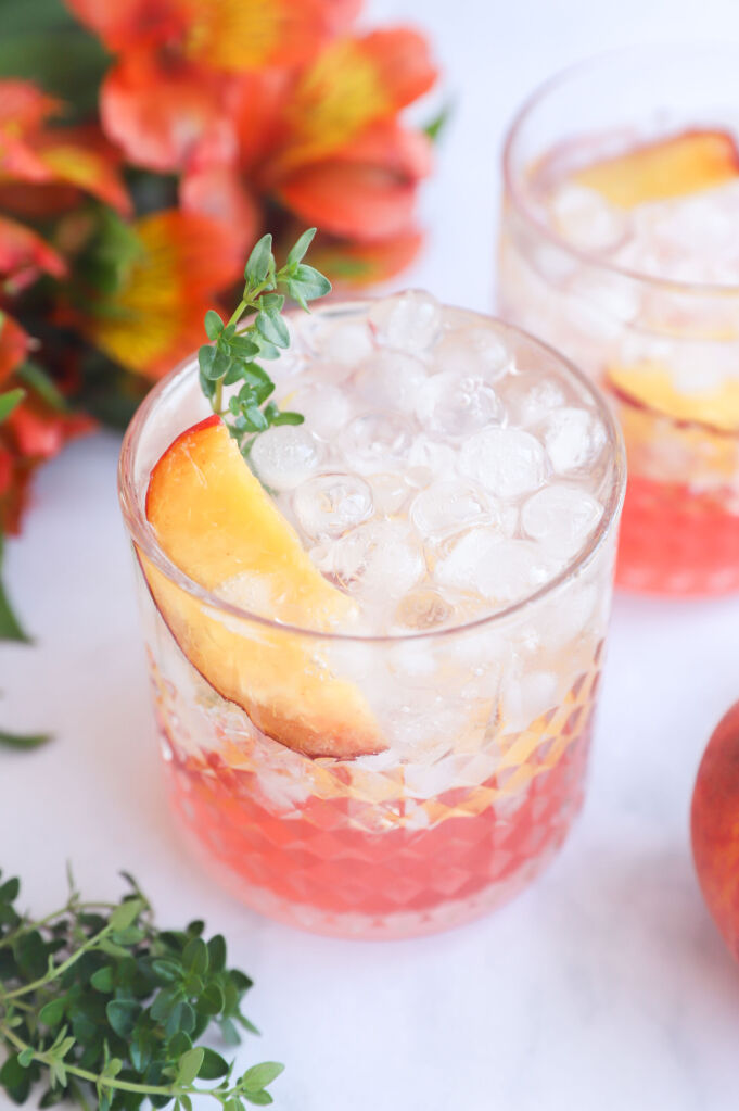 Peaches and thyme mocktail served in a glass with ice