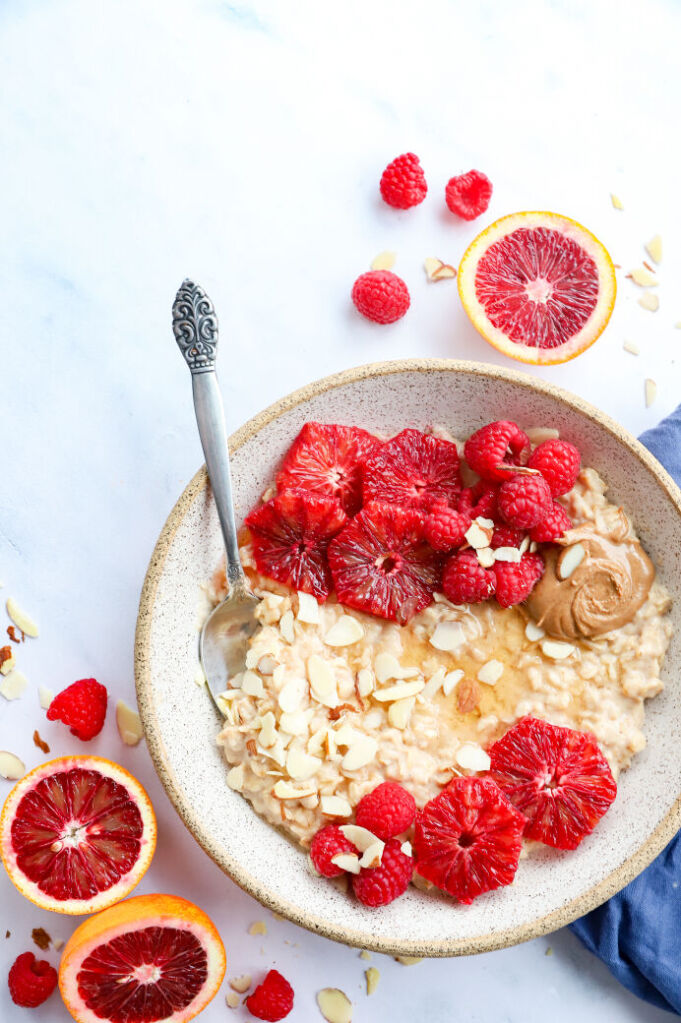 Raspberry oatmeal with blood oranges, almond butter, and fresh fruit