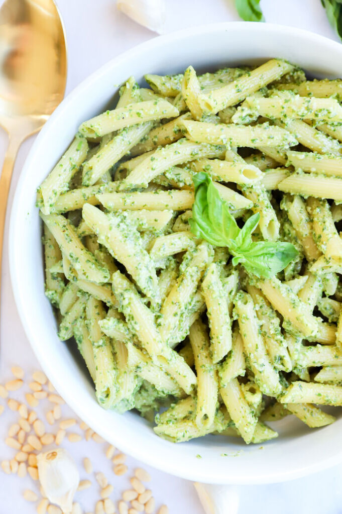 Pasta with creamy pesto sauce, pine nuts, and fresh basil