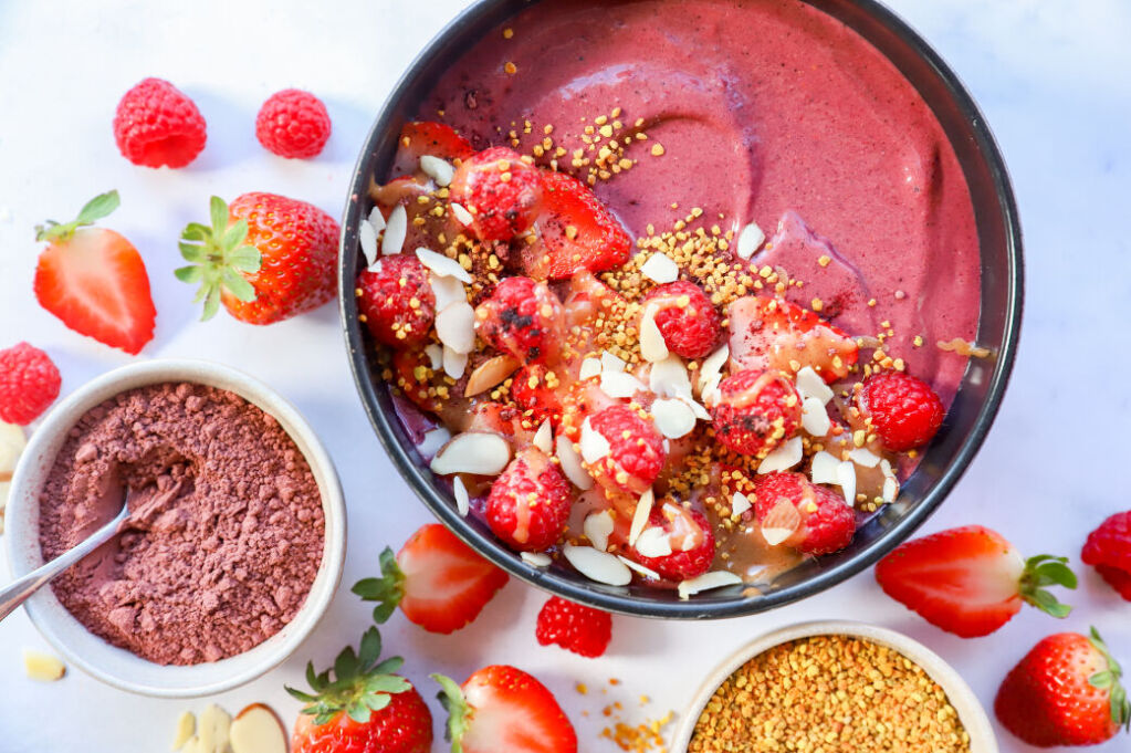 Healthy hibiscus smoothie bowl topped with fresh fruit and favorite toppings