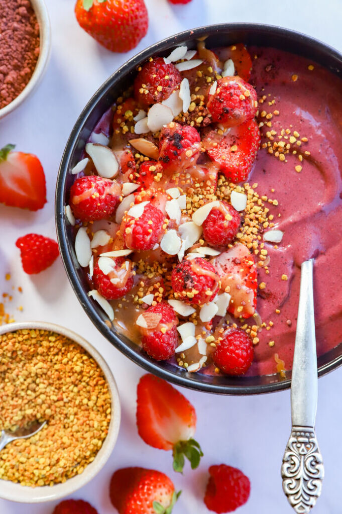 Healthy hibiscus smoothie bowl topped with fresh fruit and favorite toppings