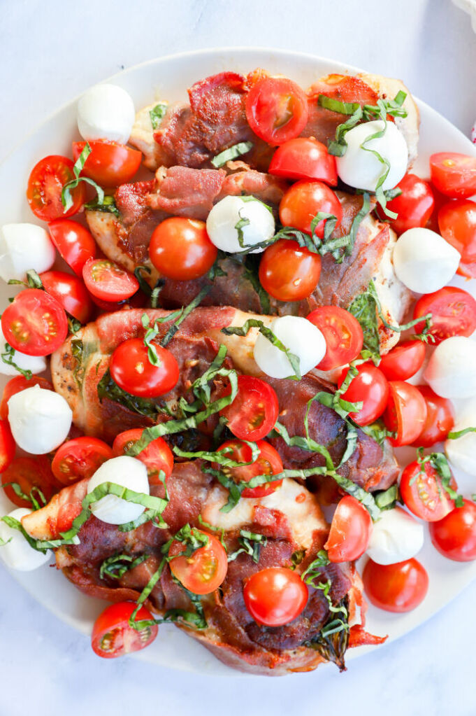 Caprese chicken saltimbocca with prosciutto, cheese, and basil leaves