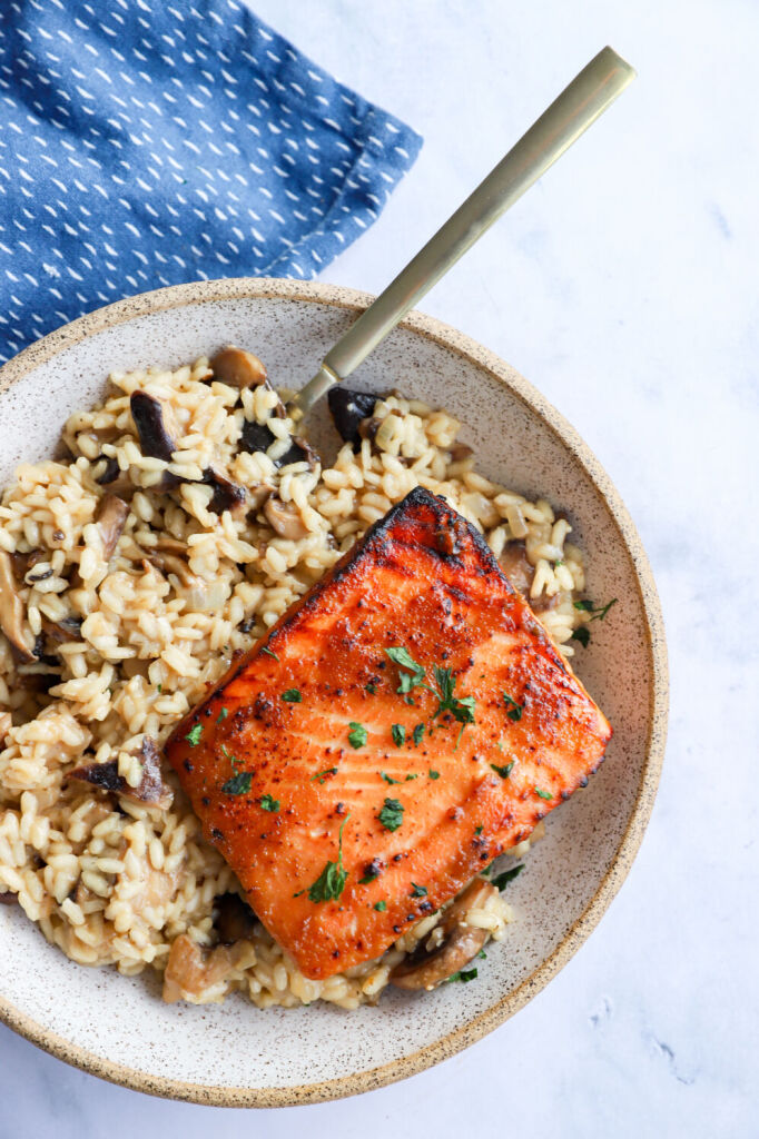 Salmon risotto with miso glaze, garnished with grated parmesan cheese