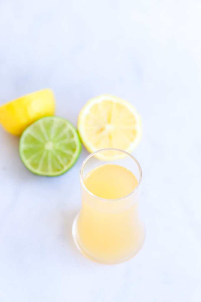 Non-Alcoholic Green Tea Shot with shot glasses and fresh citrus slices