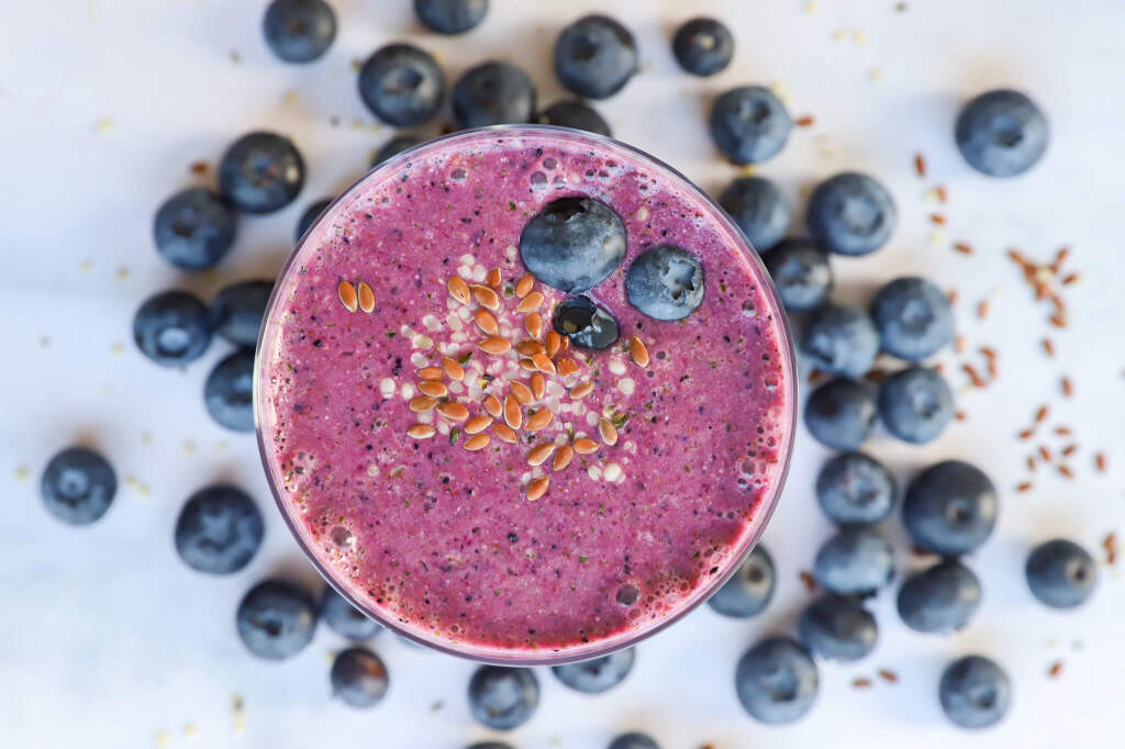 Detoxifying banana beet smoothie in a glass with fresh beets and bananas