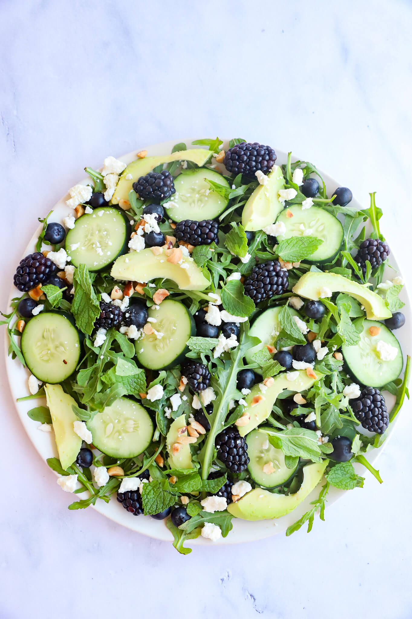 A bowl of fresh Blackberry, Avocado, and Arugula Salad for hormone balancing