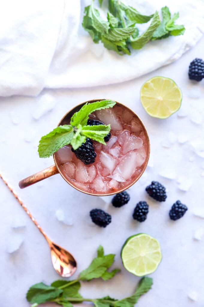 Fresh blackberry mule mocktail garnished with lime slices and blackberries