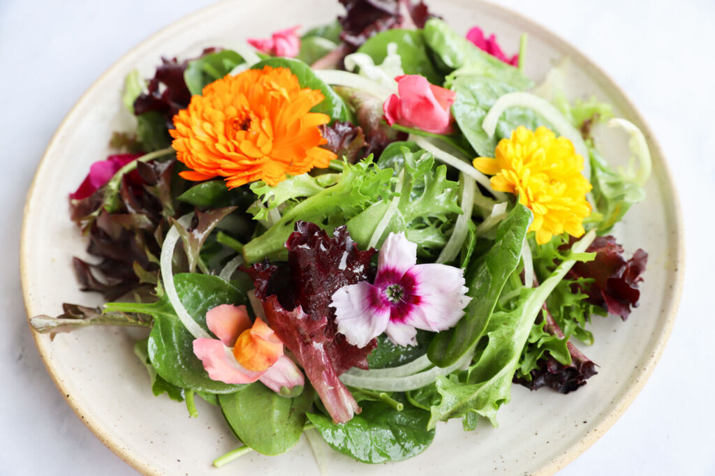 Garden salad with edible flowers and apple cider vinegar dressing