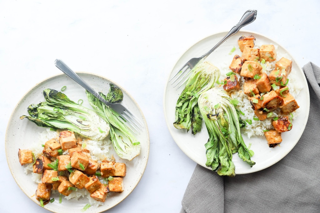 Close-up of baked miso tofu with bok choy on a rustic plate for hormone balance