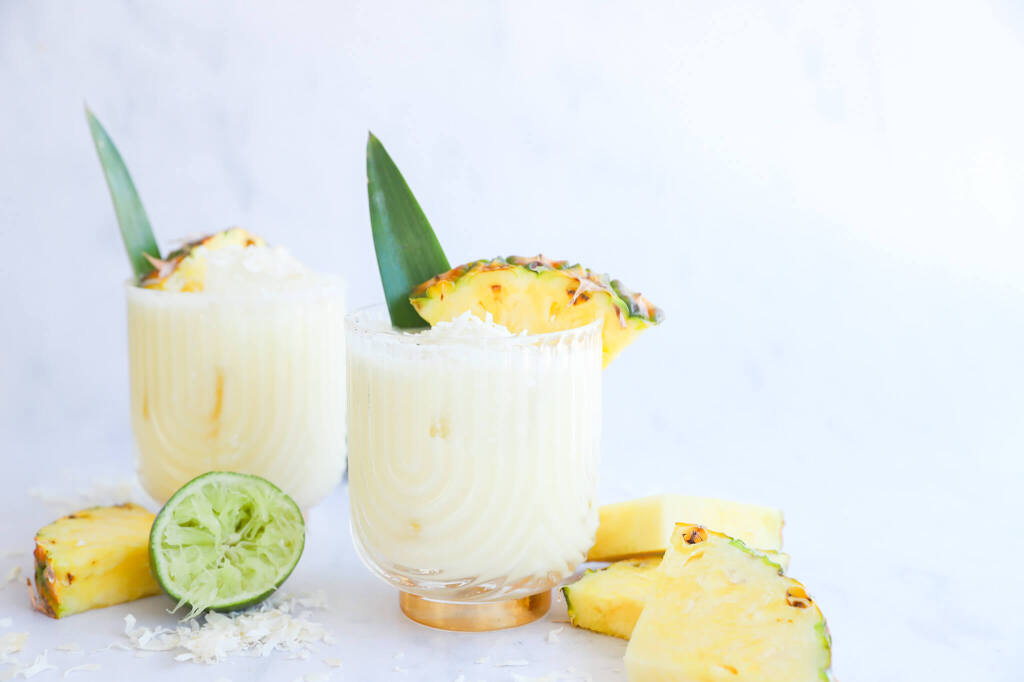 Healthy pineapple coconut water mocktail in a glass with pineapple garnish