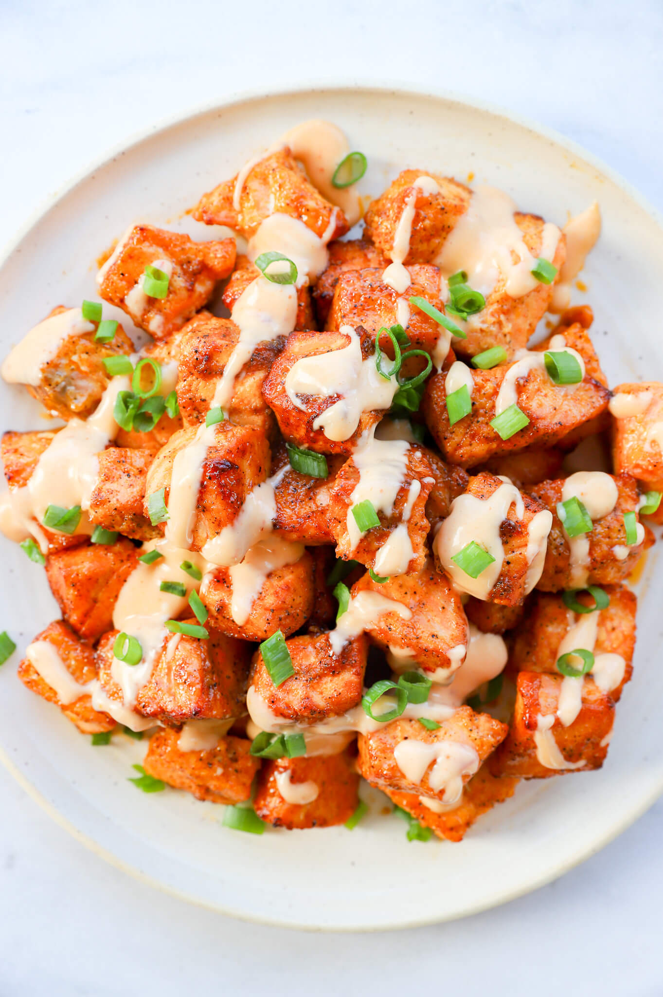 Crispy Bang Bang air fryer salmon bites on a plate