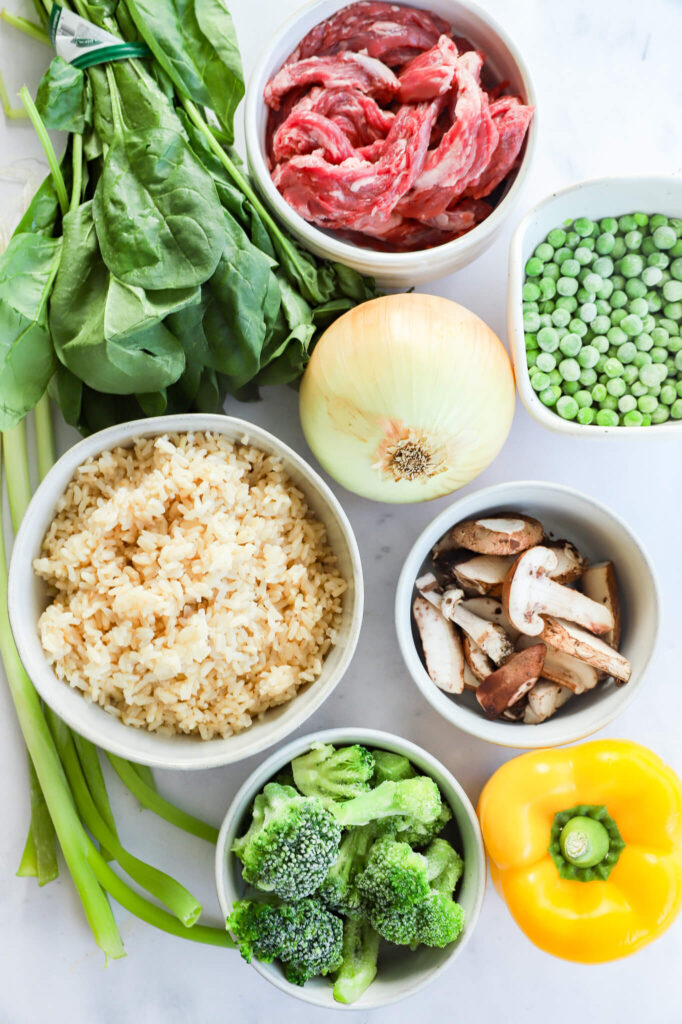 Ingredients for beef fried rice including ground beef, rice, soy sauce, and vegetables