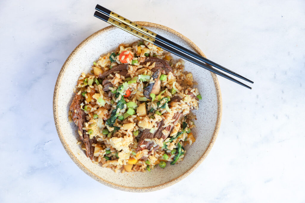 Ground beef fried rice with colorful vegetables in a skillet