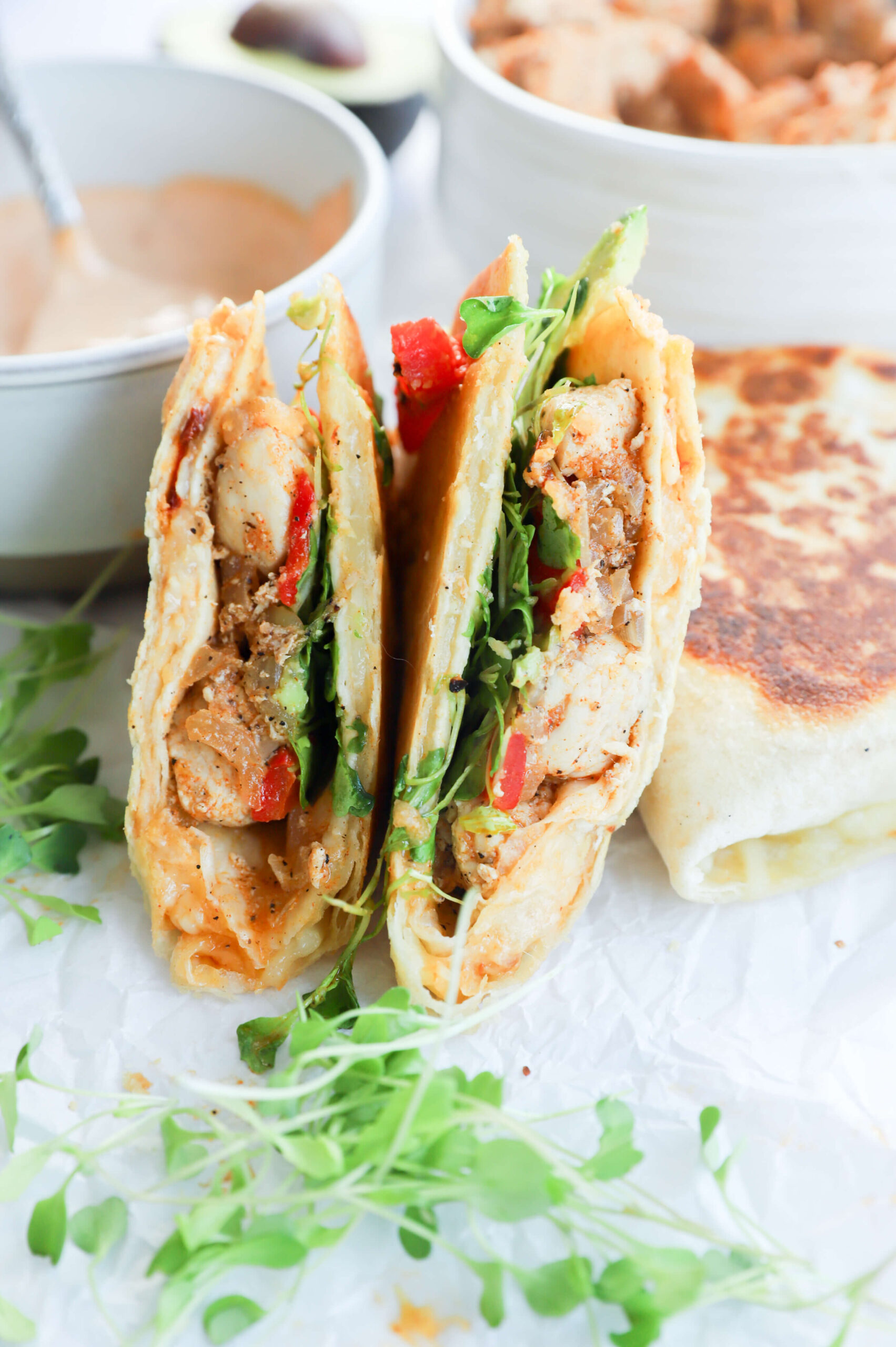 A wrap filled with chipotle chicken, avocado, and melted cheese