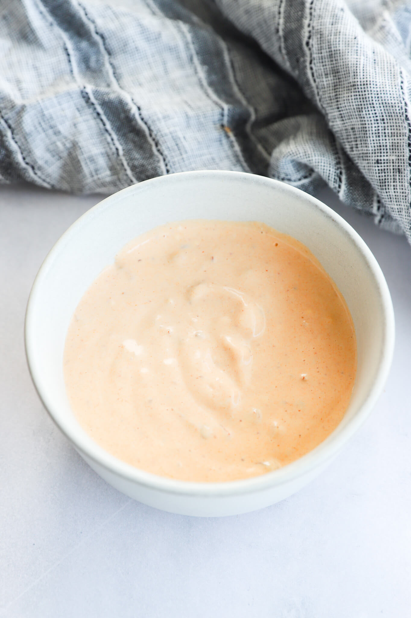 A bowl of chipotle Greek yogurt sauce with a spoon.