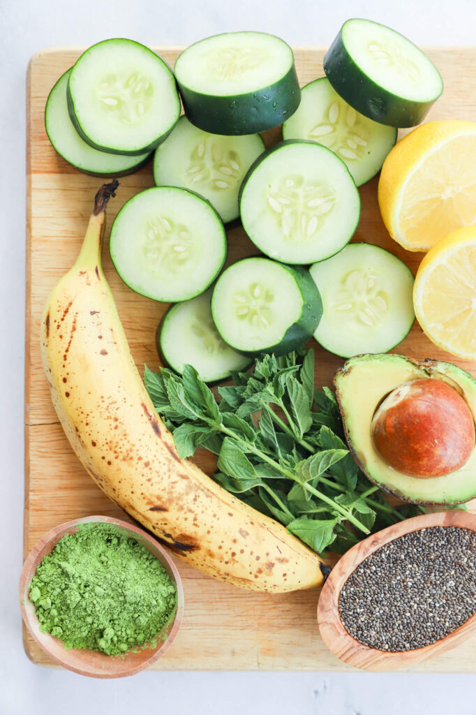 Overhead shot of ingredients for cucumber mint matcha smoothie including cucumber, mint, and matcha powder