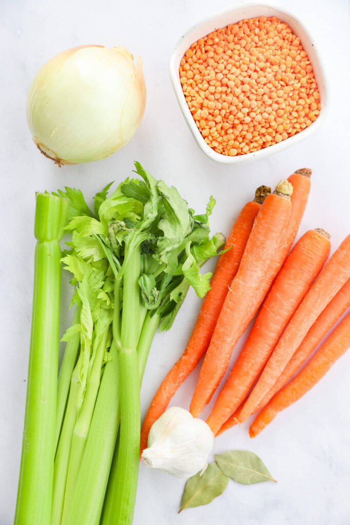 Overhead shot of ingredients for French carrot lentil soup including carrots, lentils, and spices