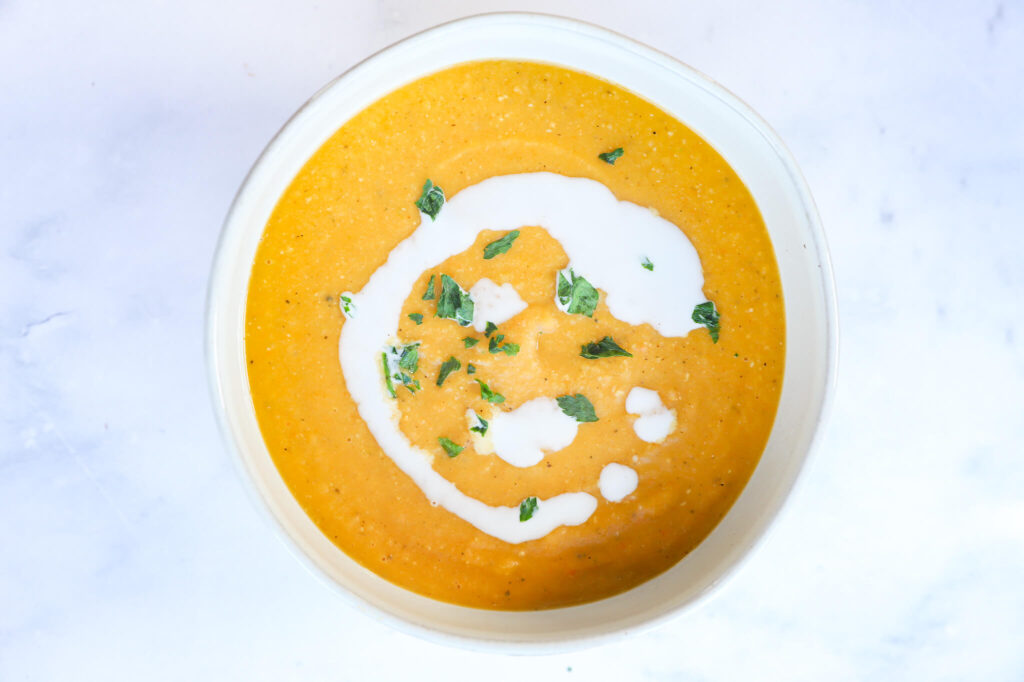 A bowl of French carrot and red lentil soup with herbs